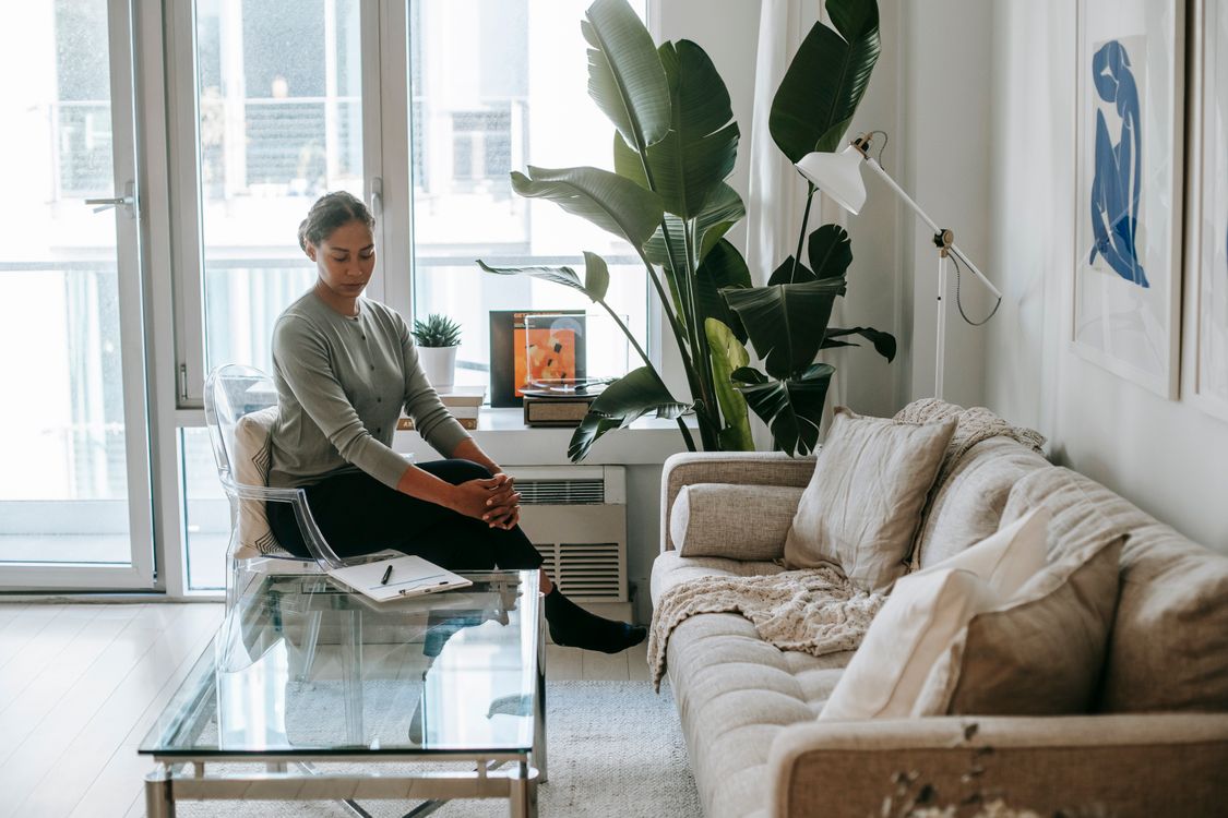 Female therapist sitting calmly with a clipboard preparing for a client therapy session